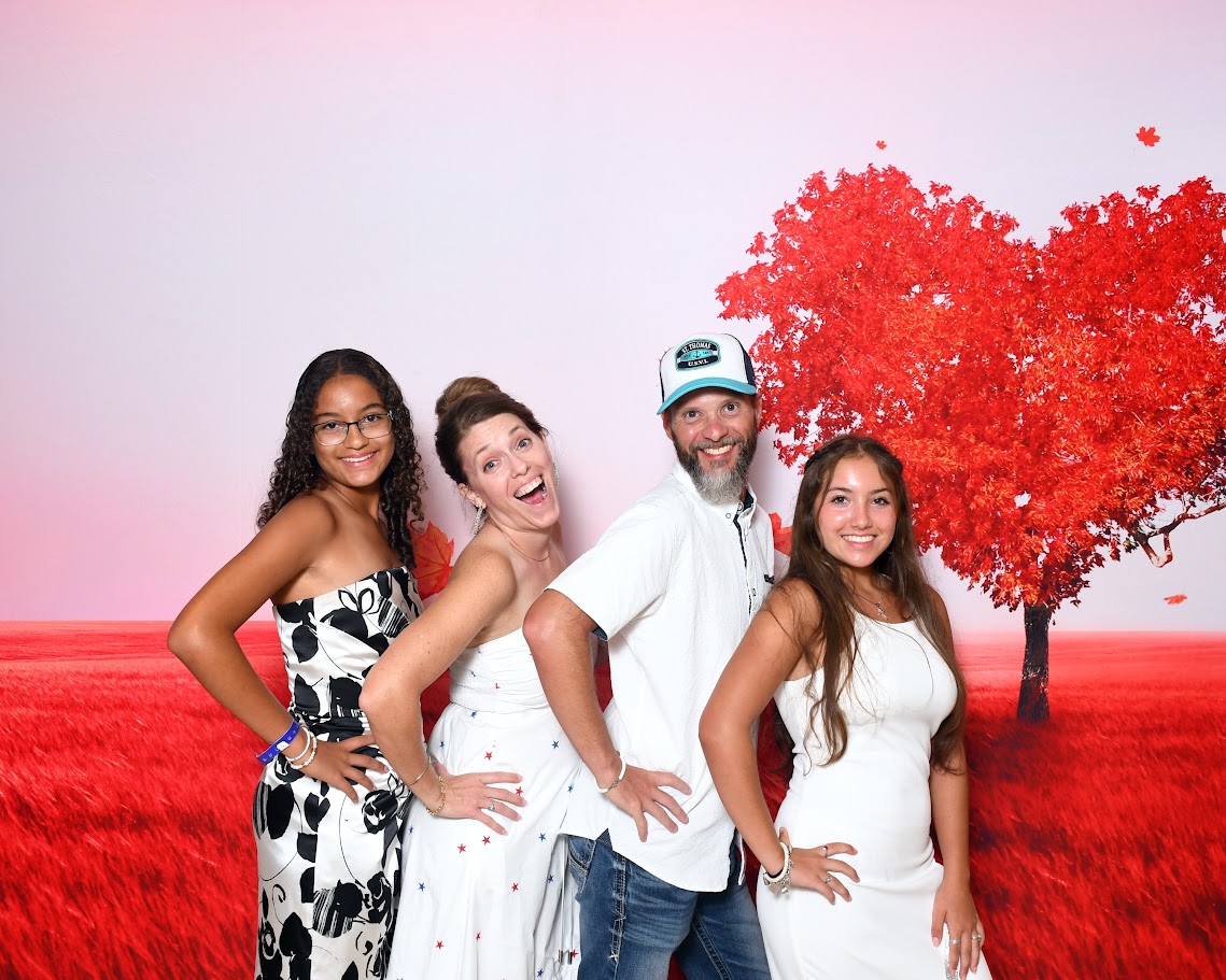The Purpose Filled family together in front of a bright red autumn landscape